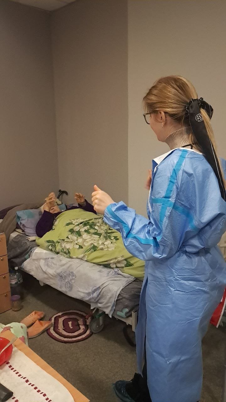 Лікар-реабілітолог оглядає лежачого пацієнта похилого віку в пансіонаті Кращий у Харкові