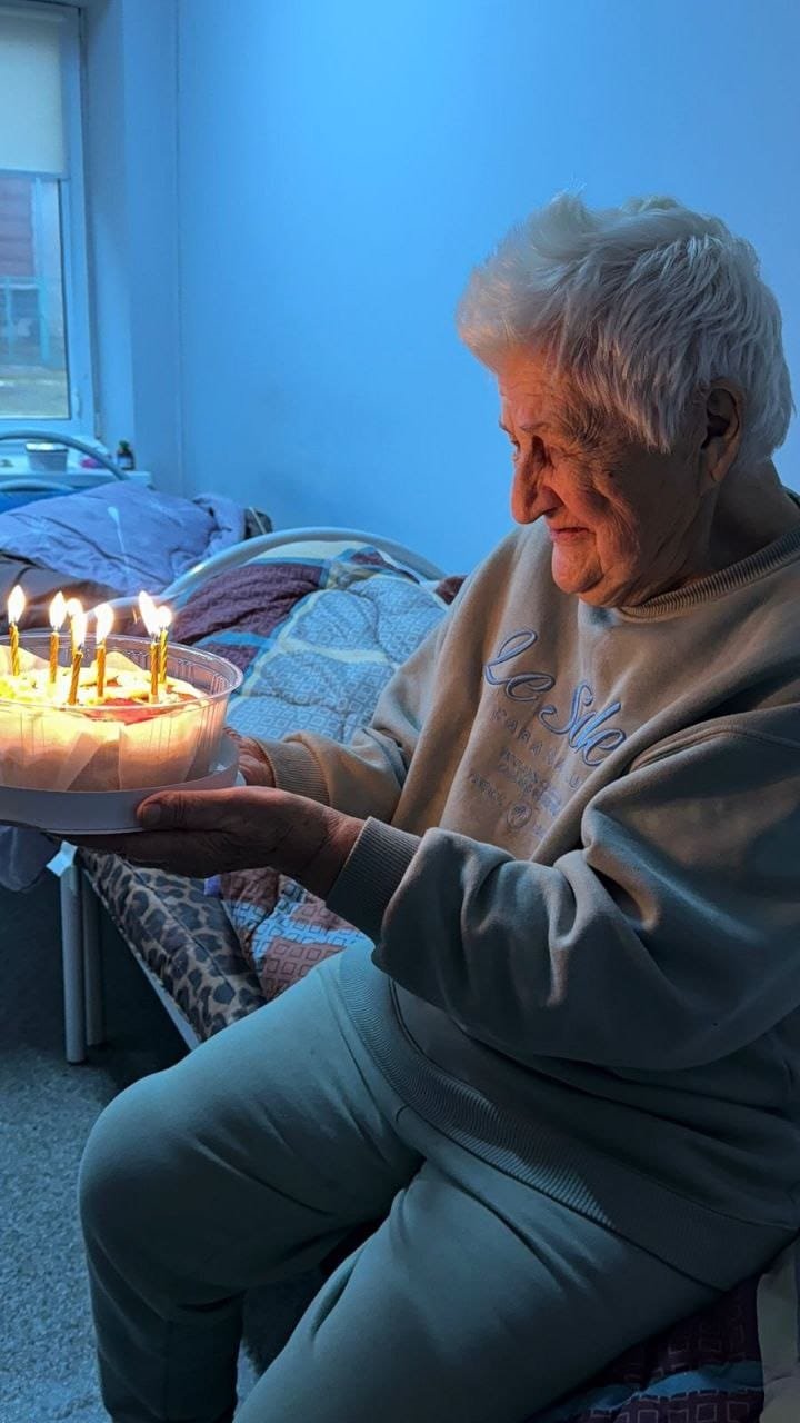 Мешканка пансіонату Кращий задуває свічки на святковому торті